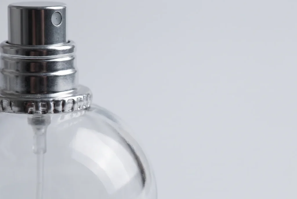 Sertissage d'un flacon de parfum vu de près, le détail qui trahit une contrefaçon